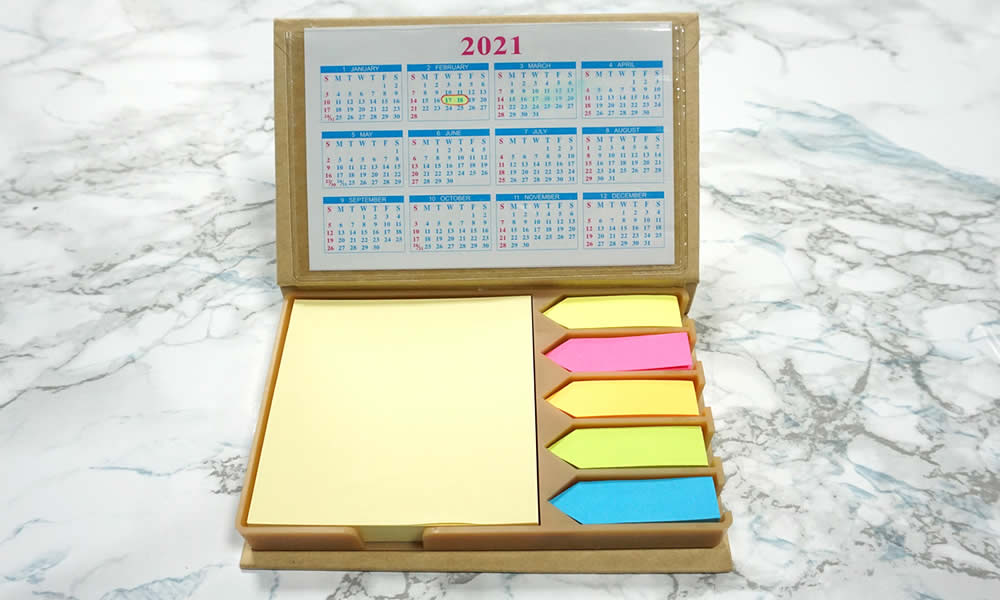 set calendario con post-it e segnapagina su tavolo marmo