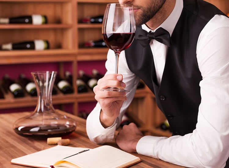 Mezzobusto sommelier che degusta vino rosso